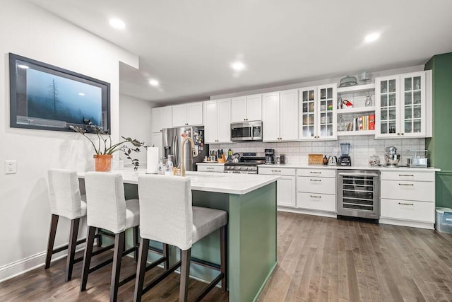 112 Oak Hill Ave, Delaware, OH 43015 - kitchen featuring beverage cooler, stainless steel appliances, a kitchen breakfast bar, light countertops, and tasteful backsplash