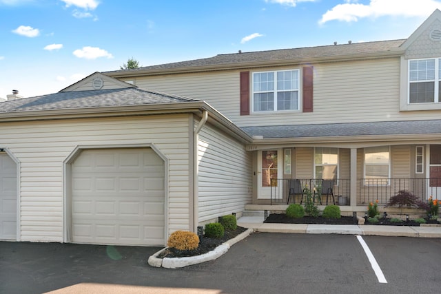 1814 Bennigan Dr Unit 88B, Hilliard, OH 43026 - view of front of house featuring covered porch, driveway, roof with shingles, and an attached garage