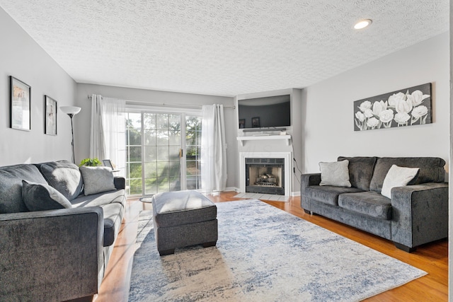 1814 Bennigan Dr Unit 88B, Hilliard, OH 43026 - living area with a textured ceiling, wood finished floors, and a fireplace with flush hearth