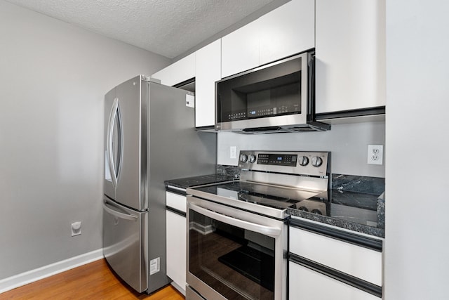 1814 Bennigan Dr Unit 88B, Hilliard, OH 43026 - kitchen with appliances with stainless steel finishes, light wood-style flooring, white cabinetry, and a textured ceiling