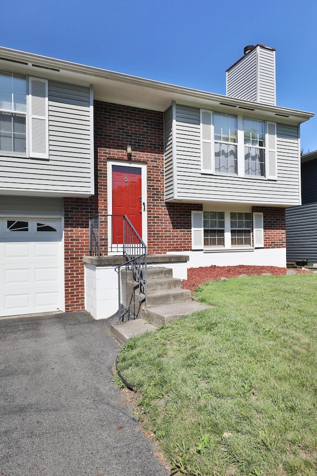 7805 Kiowa Way, Columbus, OH 43085 - doorway to property featuring brick siding, a garage, a lawn, and a chimney