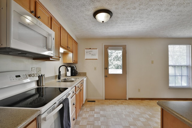 7805 Kiowa Way, Columbus, OH 43085 - kitchen featuring white appliances, brown cabinets, a textured ceiling, and light countertops