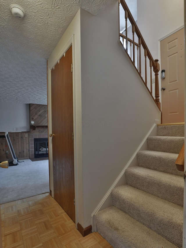 7805 Kiowa Way, Columbus, OH 43085 - staircase featuring a tiled fireplace and a textured ceiling