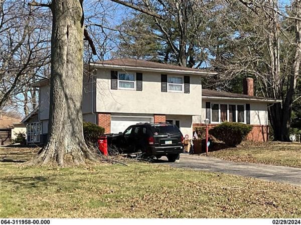 218 Blacks Rd, Pataskala, OH 43062 - split level home with stucco siding, brick siding, a garage, driveway, and a front lawn