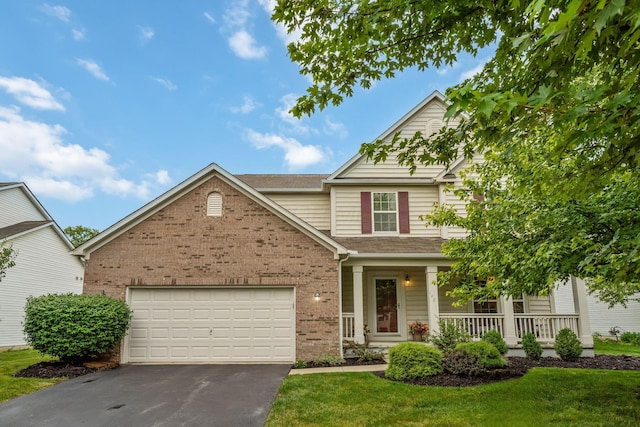 142 Blakemore Dr, Delaware, OH 43015 - traditional-style house featuring brick siding, asphalt driveway, a porch, a garage, and a front yard