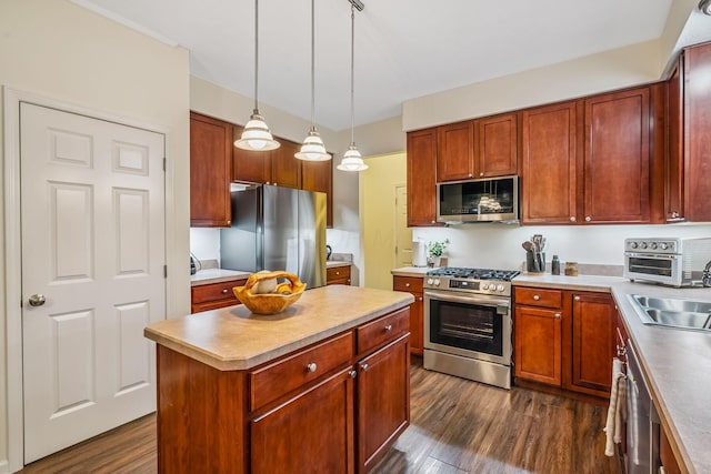 142 Blakemore Dr, Delaware, OH 43015 - kitchen featuring stainless steel appliances, dark wood-style flooring, decorative light fixtures, a center island, and light countertops
