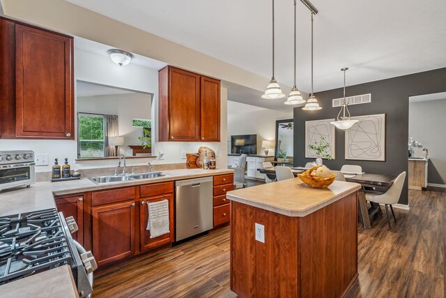 142 Blakemore Dr, Delaware, OH 43015 - kitchen with stainless steel dishwasher, dark wood-style floors, light countertops, gas stove, and pendant lighting