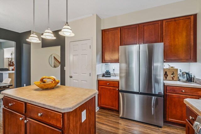 142 Blakemore Dr, Delaware, OH 43015 - kitchen featuring freestanding refrigerator, dark wood finished floors, light countertops, hanging light fixtures, and a kitchen island