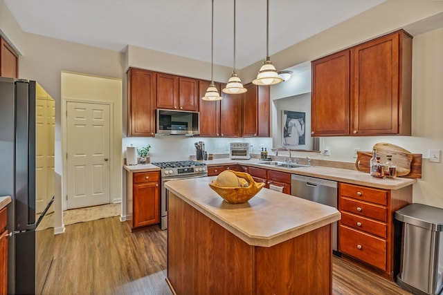 142 Blakemore Dr, Delaware, OH 43015 - kitchen featuring appliances with stainless steel finishes, dark wood-style flooring, light countertops, a center island, and hanging light fixtures
