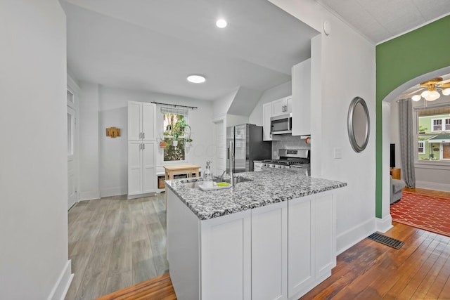 116 W Longview Ave, Columbus, OH 43202 - kitchen with stainless steel appliances, light wood-style floors, white cabinets, and plenty of natural light