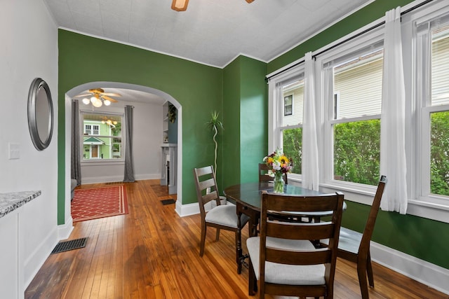 116 W Longview Ave, Columbus, OH 43202 - dining space with a ceiling fan, wood-type flooring, arched walkways, healthy amount of natural light, and ornamental molding