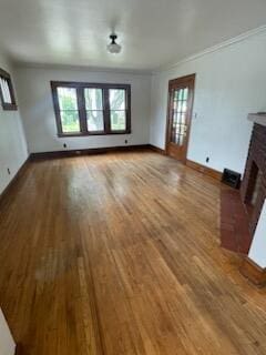 6607 Vandalia Ave, Cleveland, OH 44144 - unfurnished living room featuring a brick fireplace, ornamental molding, and wood finished floors