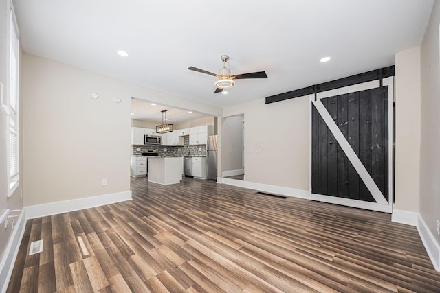 765 Campbell Ave, Columbus, OH 43222 - unfurnished living room featuring a barn door, dark wood-style floors, a ceiling fan, and recessed lighting