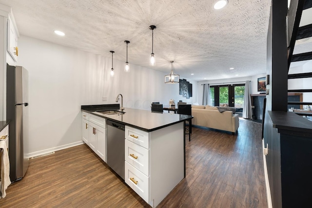 1768 Lake Meadow Dr Unit 1768H, Reynoldsburg, OH 43068 - kitchen featuring appliances with stainless steel finishes, dark countertops, a peninsula, white cabinets, and a textured ceiling