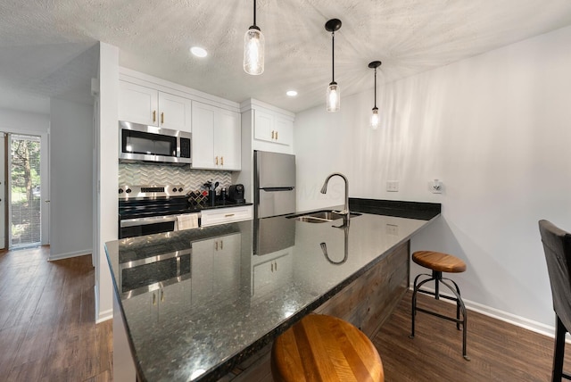 1768 Lake Meadow Dr Unit 1768H, Reynoldsburg, OH 43068 - kitchen with stainless steel appliances, dark wood-style floors, a breakfast bar, white cabinetry, and backsplash