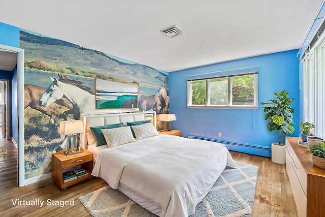 1282 Lawndale Rd, Marion, OH 43302 - bedroom with a baseboard radiator, wood finished floors, and an accent wall