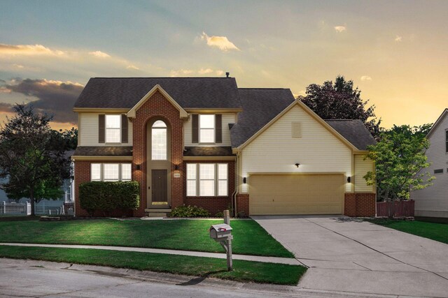 5899 Cove Point Ct, Columbus, OH 43228 - traditional-style house with concrete driveway, an attached garage, brick siding, a yard, and roof with shingles