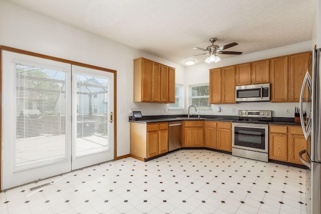 5899 Cove Point Ct, Columbus, OH 43228 - kitchen featuring appliances with stainless steel finishes, light floors, dark countertops, and a ceiling fan