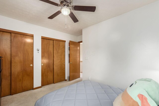 5899 Cove Point Ct, Columbus, OH 43228 - carpeted bedroom with two closets, a textured ceiling, and ceiling fan