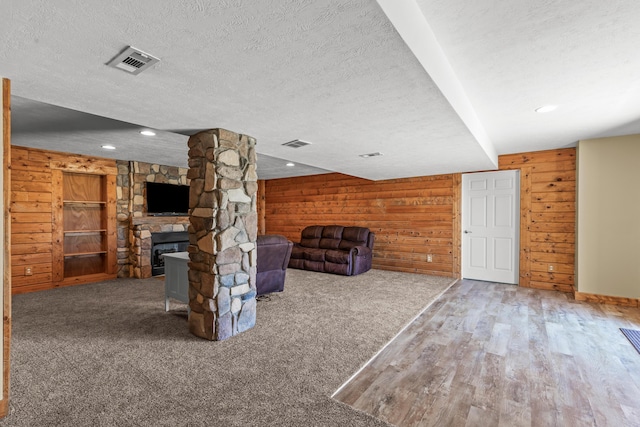 3582 Panhandle Rd, Delaware, OH 43015 - unfurnished living room featuring wood walls, a textured ceiling, recessed lighting, wood finished floors, and a fireplace