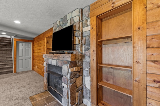 3582 Panhandle Rd, Delaware, OH 43015 - detailed view of a textured ceiling, carpet flooring, a stone fireplace, wood walls, and recessed lighting