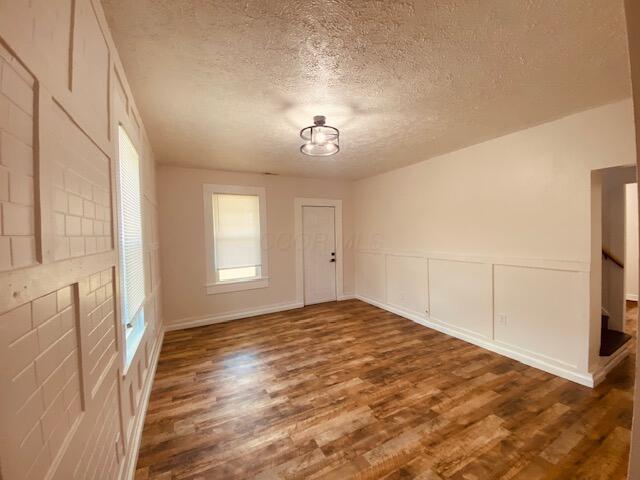 121 Maple St, London, OH 43140 - spare room with wood finished floors, a textured ceiling, plenty of natural light, and a decorative wall