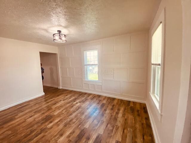 121 Maple St, London, OH 43140 - empty room featuring wood finished floors, a textured ceiling, and a decorative wall