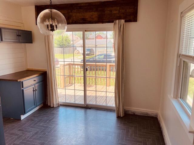 121 Maple St, London, OH 43140 - unfurnished dining area with a chandelier and baseboards