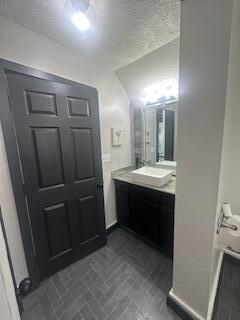 121 Maple St, London, OH 43140 - bathroom with vanity, a textured ceiling, and brick patterned flooring