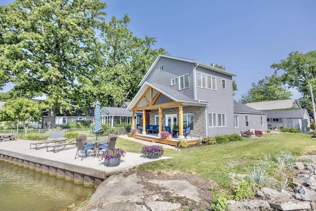 14060 Seminole Path, Lakeview, OH 43331 - back of property featuring a deck with water view, stone siding, and a patio