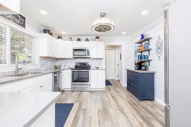 14060 Seminole Path, Lakeview, OH 43331 - kitchen with stainless steel appliances, crown molding, blue cabinetry, white cabinets, and light wood-style flooring