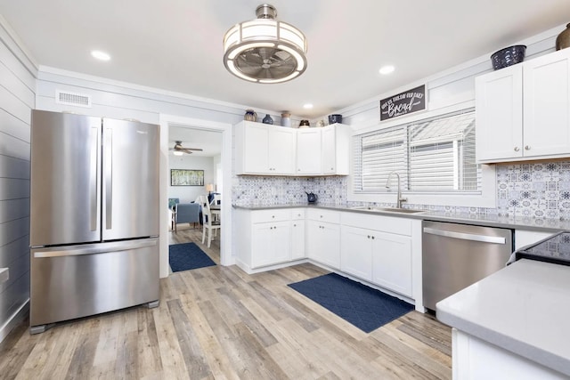 14060 Seminole Path, Lakeview, OH 43331 - kitchen featuring stainless steel appliances, a ceiling fan, decorative backsplash, light wood-type flooring, and white cabinetry