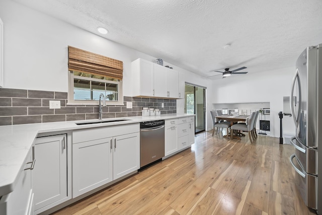 279 Old Coach Pl, Canal Winchester, OH 43110 - kitchen featuring appliances with stainless steel finishes, a ceiling fan, tasteful backsplash, plenty of natural light, and a textured ceiling