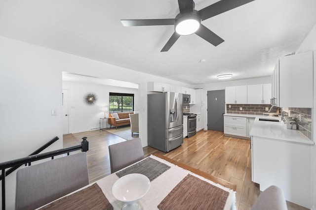 279 Old Coach Pl, Canal Winchester, OH 43110 - kitchen featuring stainless steel appliances, light countertops, light wood-style floors, white cabinets, and backsplash