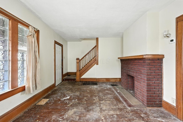 741 Heyl Ave, Columbus, OH 43206 - unfurnished living room featuring a brick fireplace and stairway