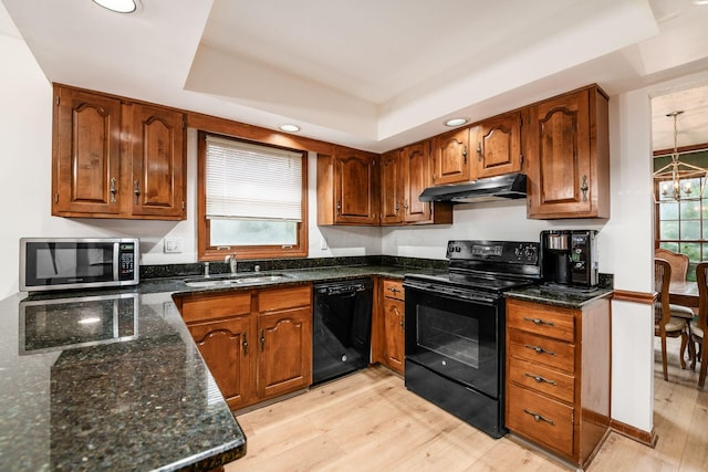 1169 Riva Ridge Blvd, Columbus, OH 43230 - kitchen with black appliances, under cabinet range hood, a raised ceiling, light wood-style flooring, and brown cabinets