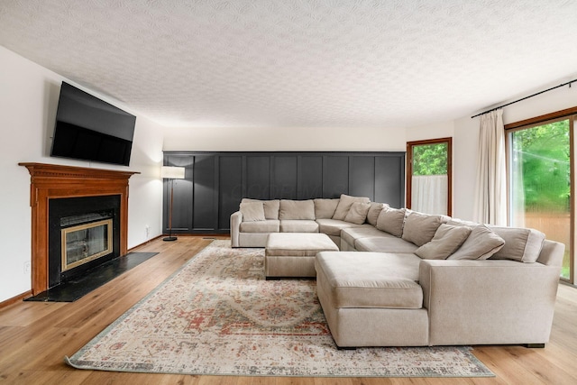 1169 Riva Ridge Blvd, Columbus, OH 43230 - living area with a textured ceiling, a fireplace with flush hearth, and light wood-style floors