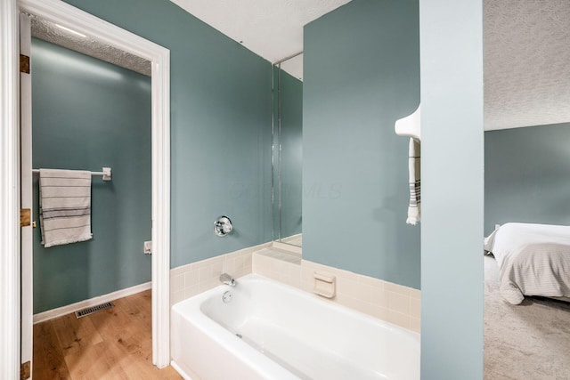 1169 Riva Ridge Blvd, Columbus, OH 43230 - bathroom featuring a garden tub, ensuite bathroom, wood finished floors, and a textured ceiling