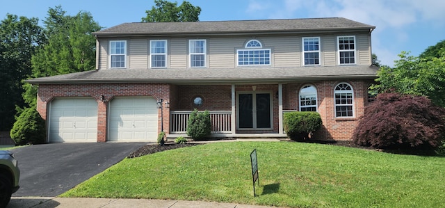 19 Ravine View Ct, Pataskala, OH 43062 - view of front of property with covered porch, an attached garage, a front yard, driveway, and brick siding