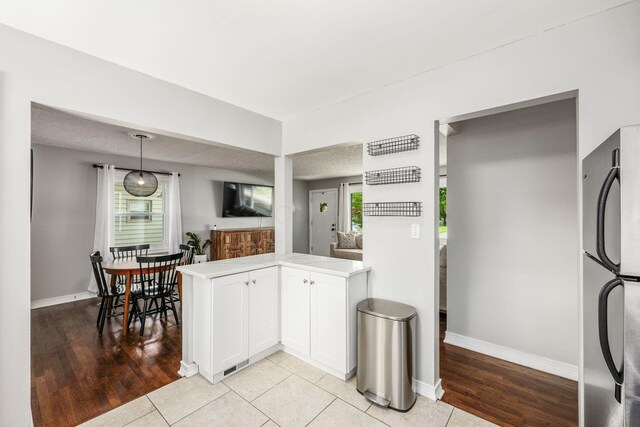 2486 Cranford Rd, Columbus, OH 43221 - kitchen with freestanding refrigerator, light countertops, light wood-style floors, and white cabinets
