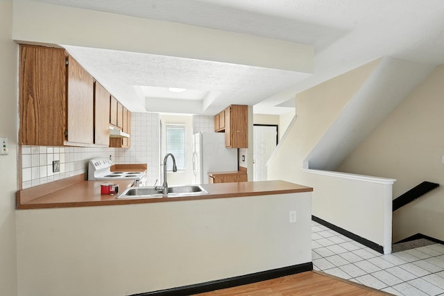 2663 Cedar Lake Dr, Dublin, OH 43016 - kitchen featuring white appliances, under cabinet range hood, a peninsula, backsplash, and brown cabinetry