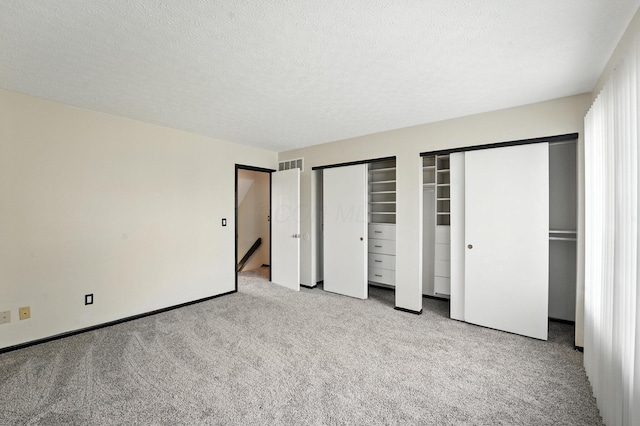 2663 Cedar Lake Dr, Dublin, OH 43016 - unfurnished bedroom featuring two closets, light carpet, and a textured ceiling