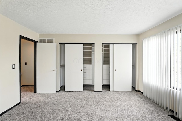 2663 Cedar Lake Dr, Dublin, OH 43016 - unfurnished bedroom with two closets, carpet, and a textured ceiling