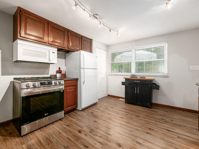 1410 Chelmsford Sq S, Columbus, OH 43229 - kitchen with white appliances, rail lighting, light wood-style flooring, brown cabinetry, and dark countertops