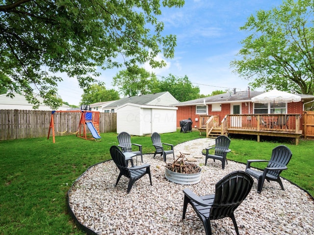 1410 Chelmsford Sq S, Columbus, OH 43229 - fenced backyard with a fire pit, a playground, a wooden deck, and a storage unit