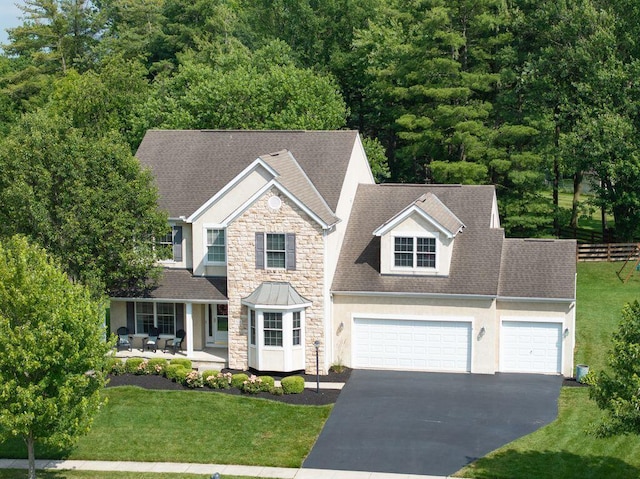 7125 Marrisey Loop, Galena, OH 43021 - view of front of home featuring stone siding, driveway, a garage, stucco siding, and roof with shingles