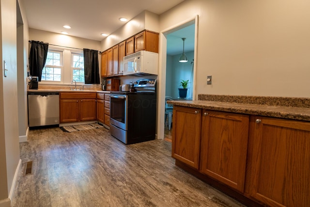 4754 Amesbury Way, Columbus, OH 43228 - kitchen featuring appliances with stainless steel finishes, brown cabinetry, dark wood finished floors, and recessed lighting