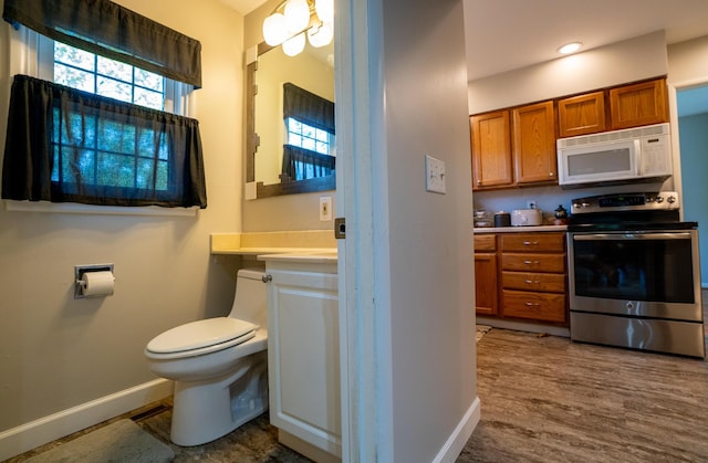 4754 Amesbury Way, Columbus, OH 43228 - kitchen featuring white microwave, stainless steel range with electric stovetop, brown cabinetry, light countertops, and dark wood-type flooring