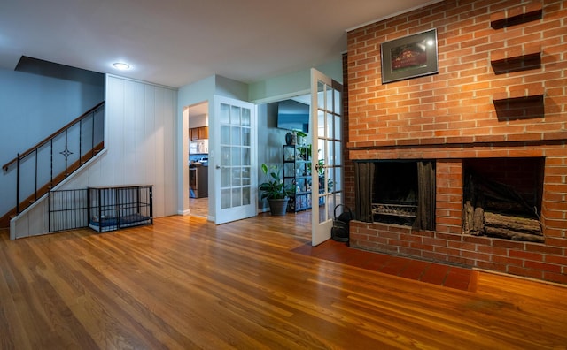4754 Amesbury Way, Columbus, OH 43228 - unfurnished living room featuring wood finished floors, a brick fireplace, stairs, and french doors
