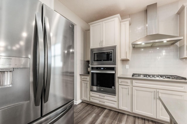3031 Sinatra Way, Powell, OH 43065 - kitchen featuring stainless steel appliances, wall chimney exhaust hood, dark wood-style floors, backsplash, and white cabinetry